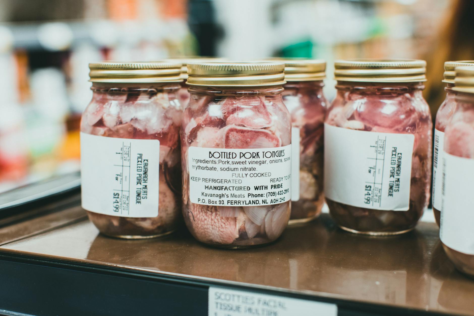 Słoiki z językami wieprzowymi ustawione na półce supermarketu