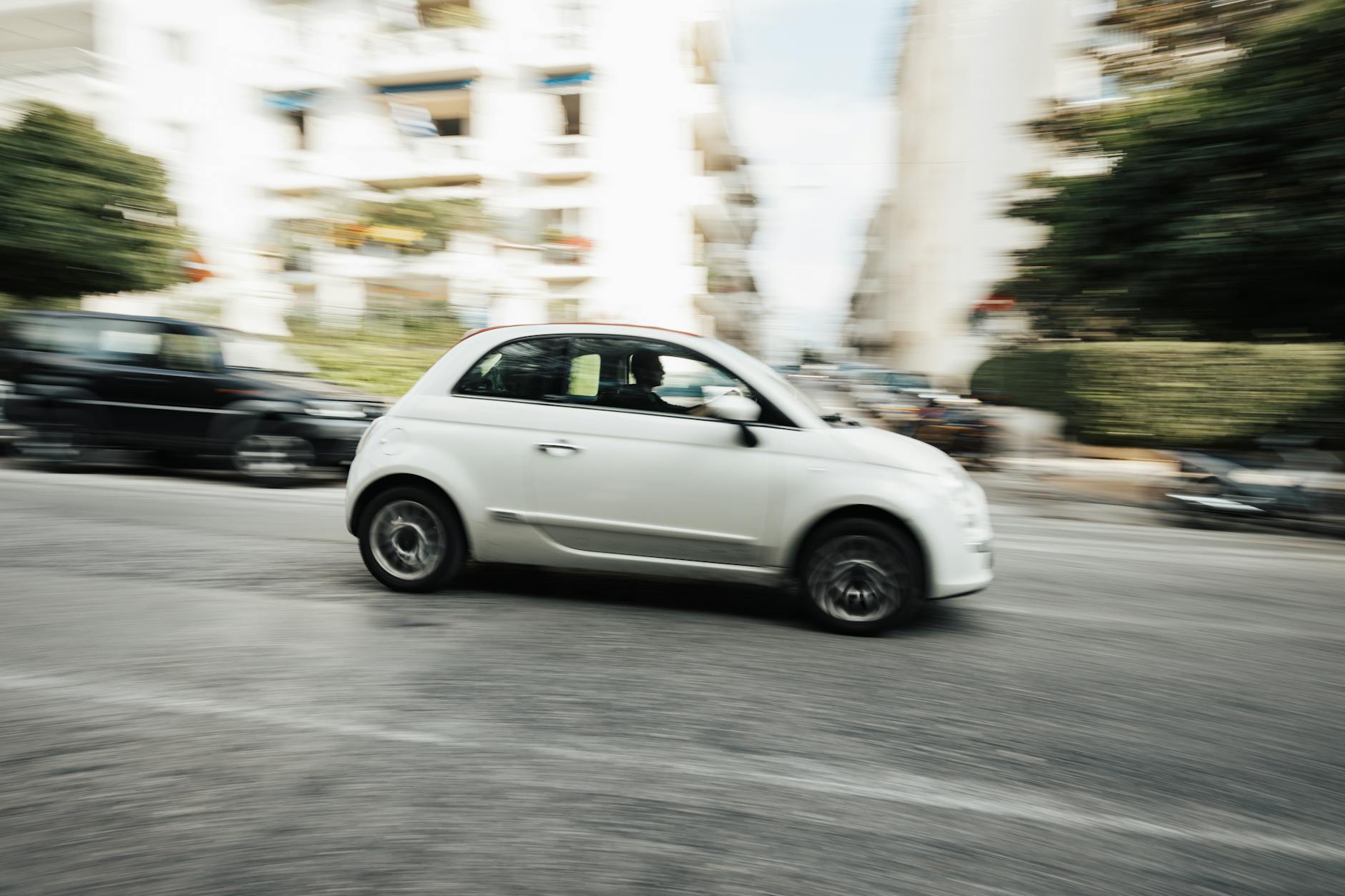 Białe miejskie auto Hyundai i10 w ruchu na ulicy miasta