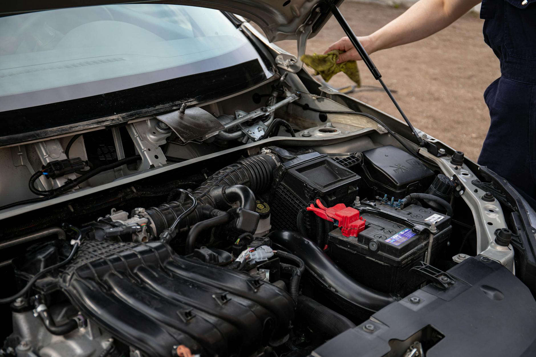 Mechanik sprawdzający silnik i akumulator w Volkswagenie podczas serwisu