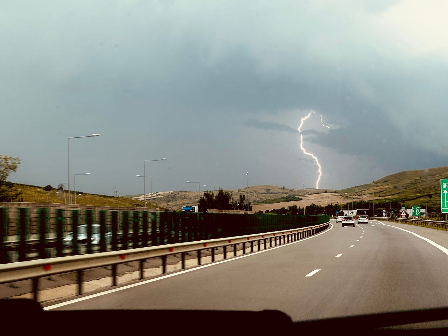 Burza z piorunami nad autostradą widziana z jadącego samochodu
